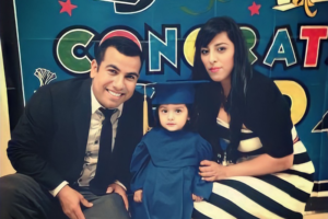 Parents with child in graduation cap and gown
